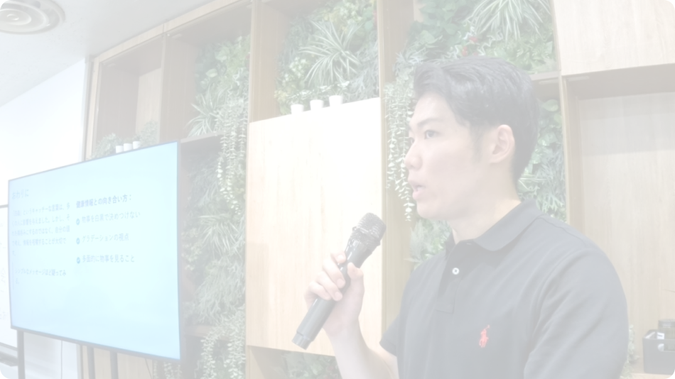 講義でマイクを持って説明する男性講師の写真