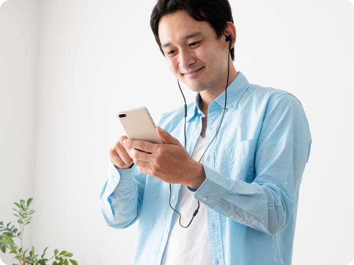 イヤホンをつけた男性がスマホを操作している様子