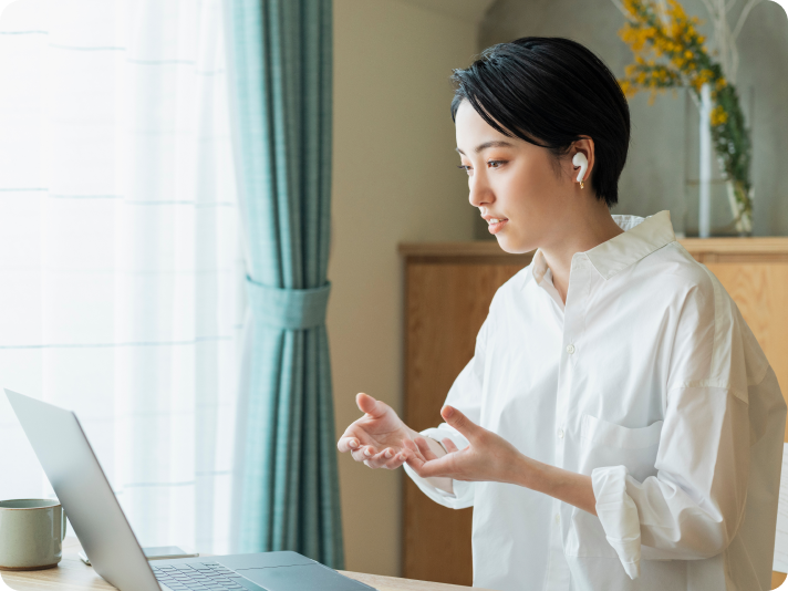女性がイヤホンをつけてパソコン相手に話している様子