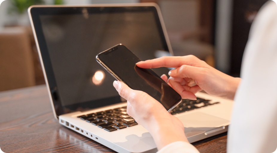 ノートパソコンとスマートフォンを併用してSNS集客やビジネス管理を行う様子